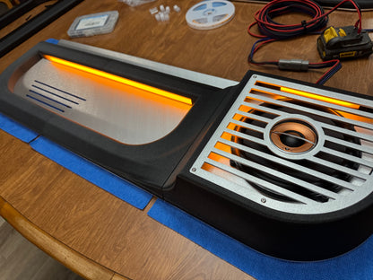 BBOR V3 door speaker panel with orange lighting strip and brushed aluminum grille on a workbench