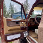 Open door of a vintage vehicle with interior details, outdoors.